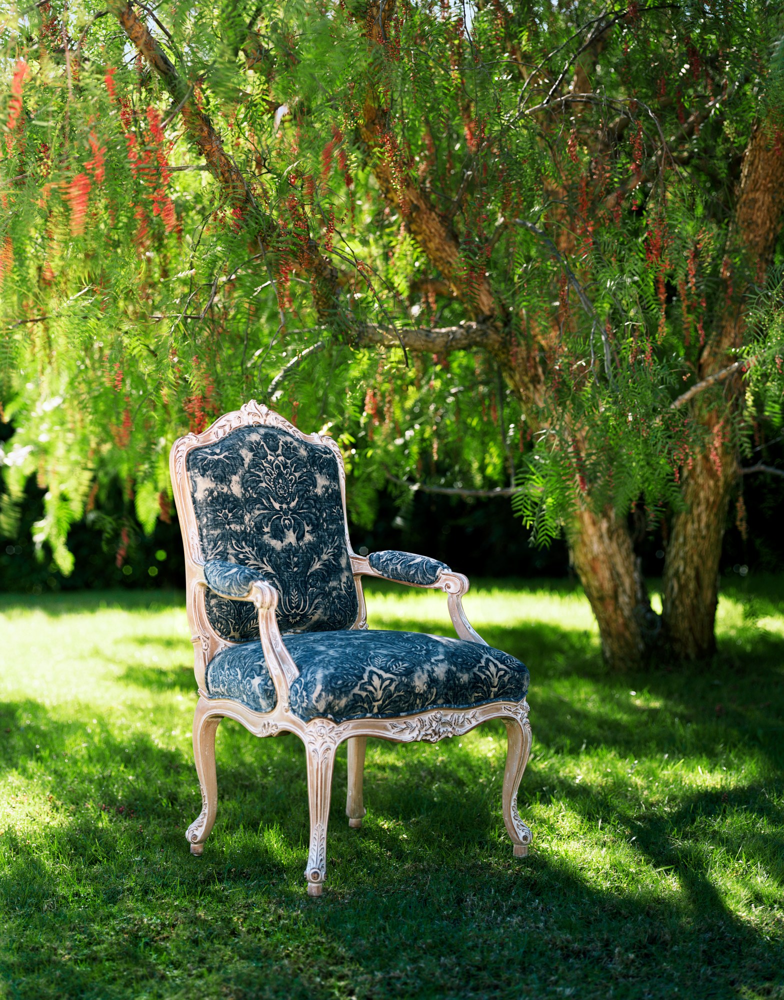 Suzanne, a carved Louis XV style armchair with a pale frame, upholstered in navy and ivory damask