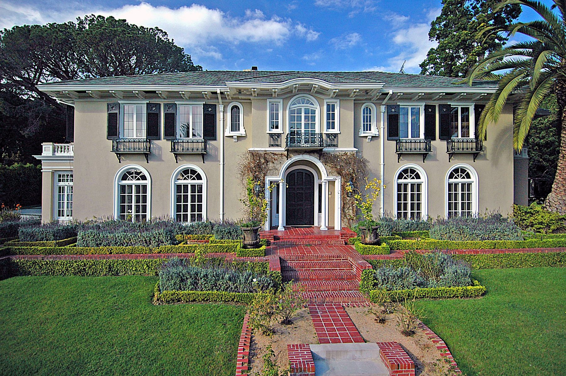 The Fuller House from the front garden, a 1916 Mediterranean facade with arched windows