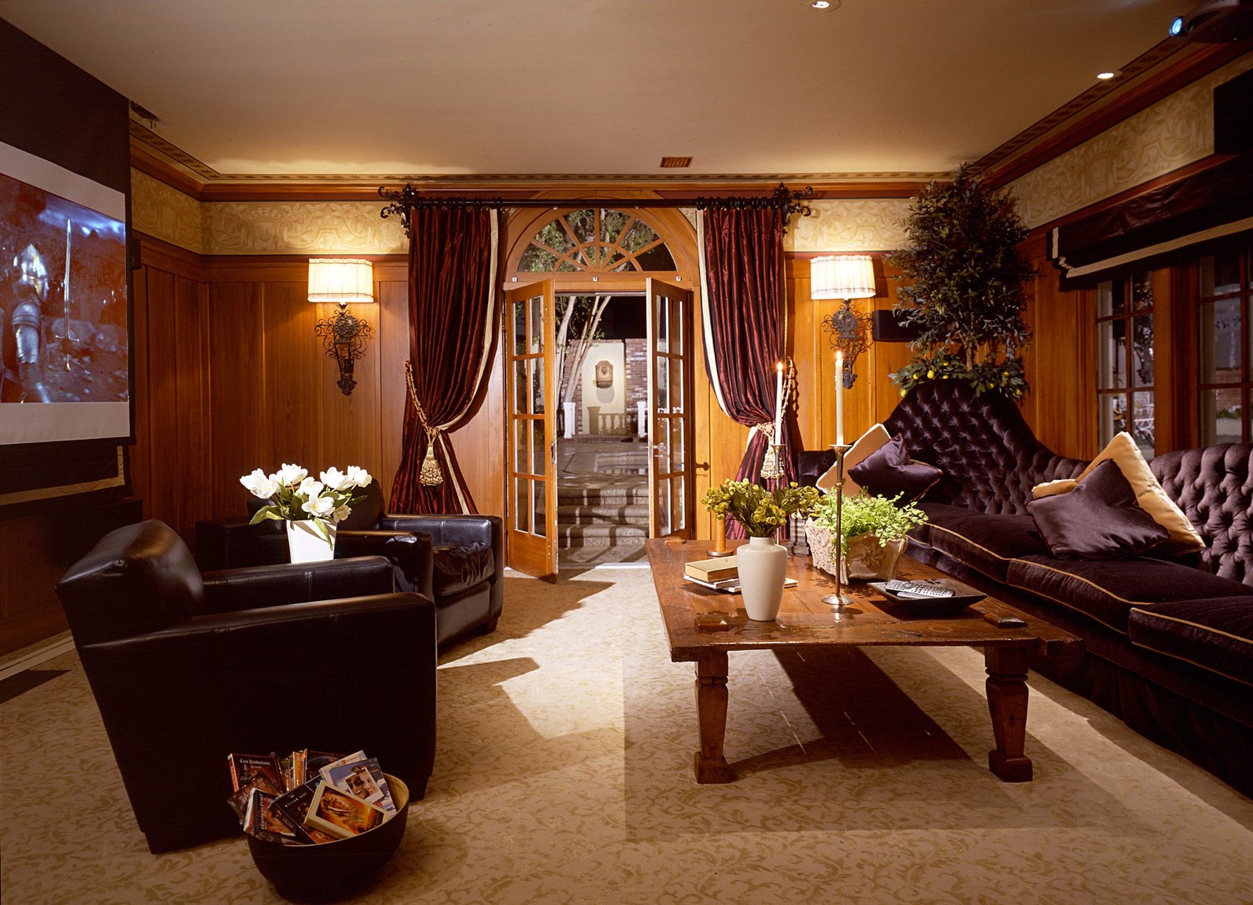 Wood-paneled theater with leather club chairs and velvet curtains