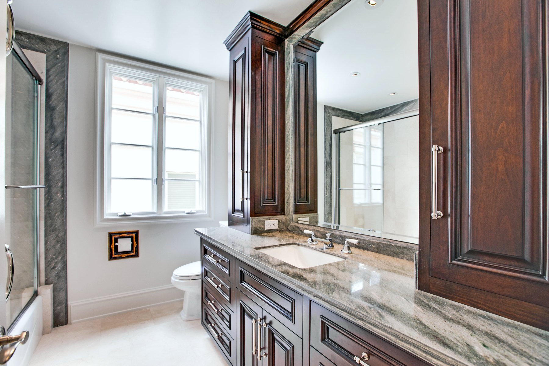Guest bath with dark wood cabinetry and stone counters