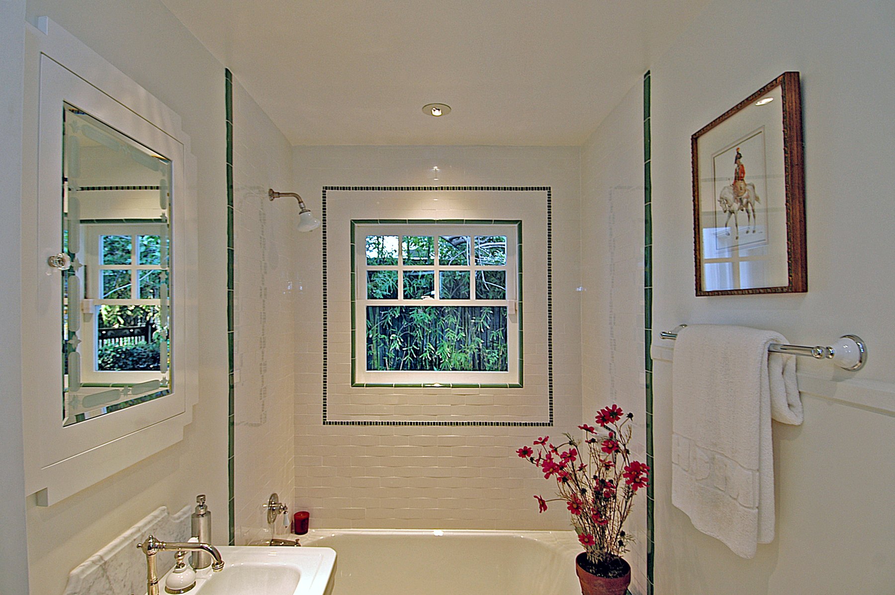 Guest bath in white tile with a framed window set into the shower wall