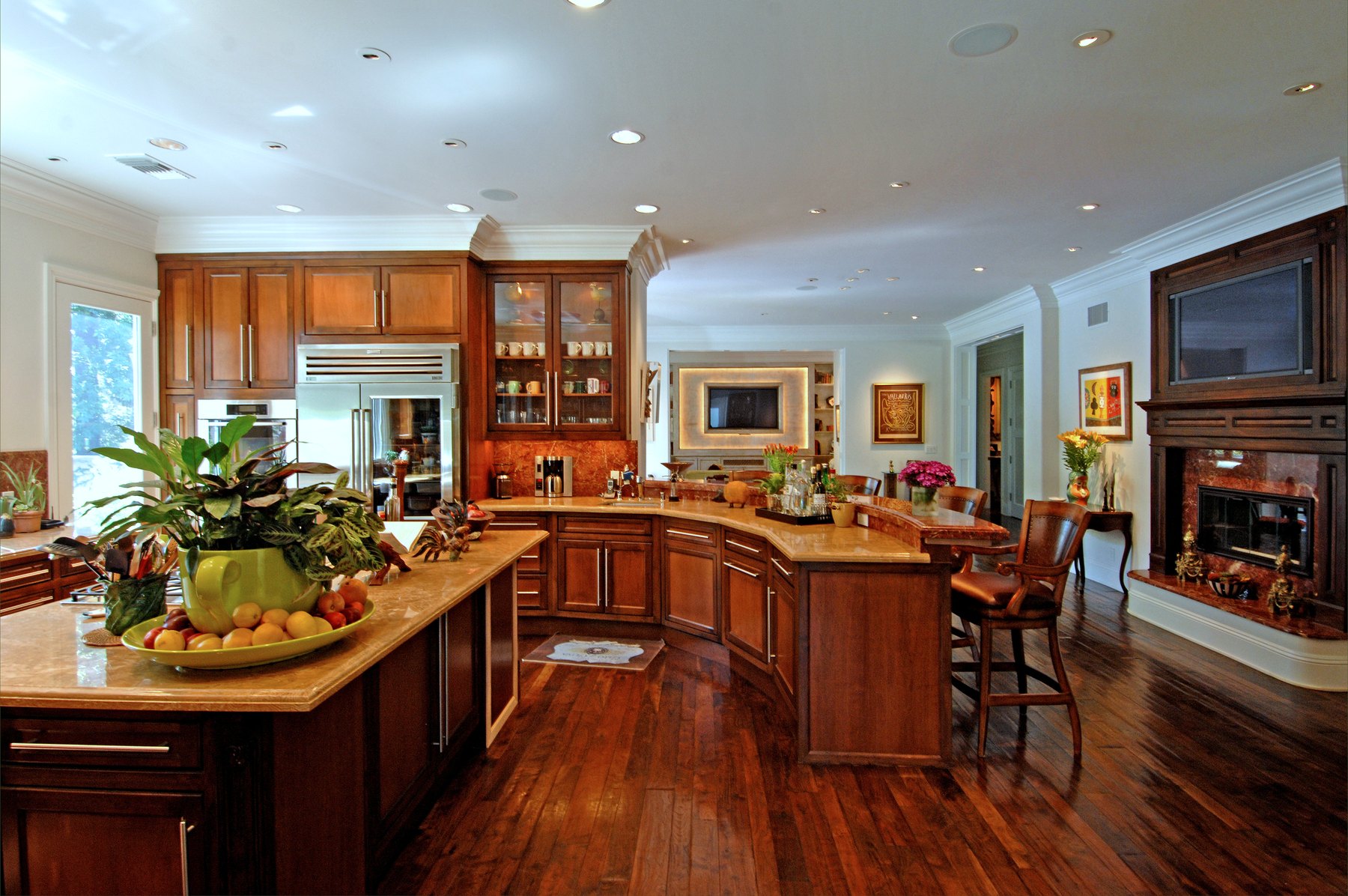 Kitchen with warm wood cabinetry, glass-fronted uppers and an island