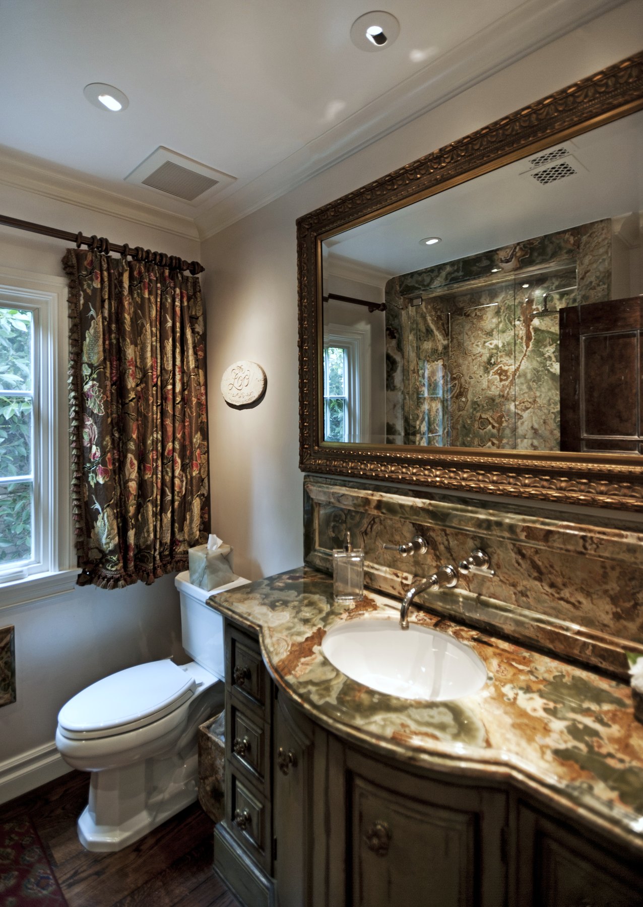 Powder room with a stone vanity and a framed mirror