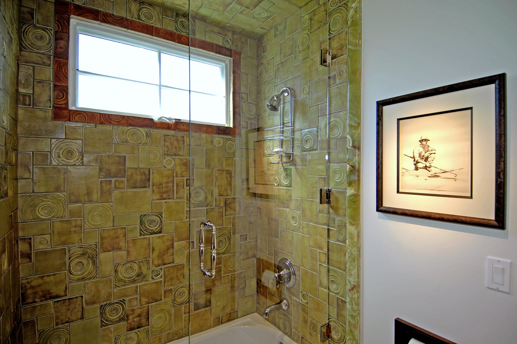 Glass shower in patterned tile with a window above
